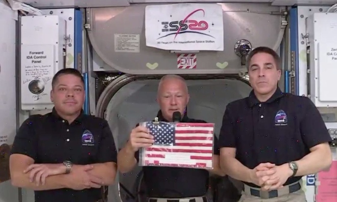 <p class="Normal">
<strong>Khi đến nơi, hai phi hành gia đã vẫy một lá cờ Mỹ mà phi hành đoàn tàu con thoi cuối cùng để lại trên ISS. Họ đã đợi 9 năm cho lần đưa người lên vũ trụ tiếp theo của NASA từ đất Mỹ.</strong></p><p class="Normal">Doug Hurley (giữa) vẫy cờ trong cuộc họp báo với Bob Behnken (trái) và phi hành gia Chris Cassidy (phải) trên Trạm Vũ trụ Quốc tế, ngày 1 tháng 6 năm 2020.  </p>