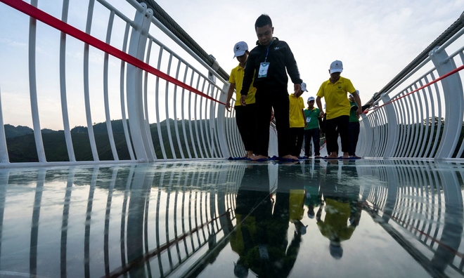<p>
Công nhân vệ sinh cây cầu kính Bạch Long trước lễ khai trương tại huyện Mộc Châu, tỉnh Sơn La, Việt Nam, ngày 28 tháng 5 năm 2022. Ảnh chụp ngày 28 tháng 5 năm 2022. REUTERS / Athit Perawongmetha</p>