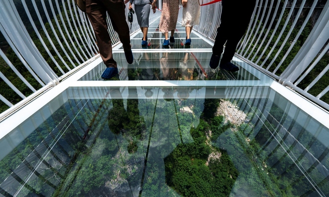<p>
Mọi người đi bộ trên cầu kính Bạch Long trong lễ khai trương tại huyện Mộc Châu, tỉnh Sơn La, Việt Nam, ngày 28 tháng 5 năm 2022. Ảnh chụp ngày 28 tháng 5 năm 2022. REUTERS / Athit Perawongmetha</p>